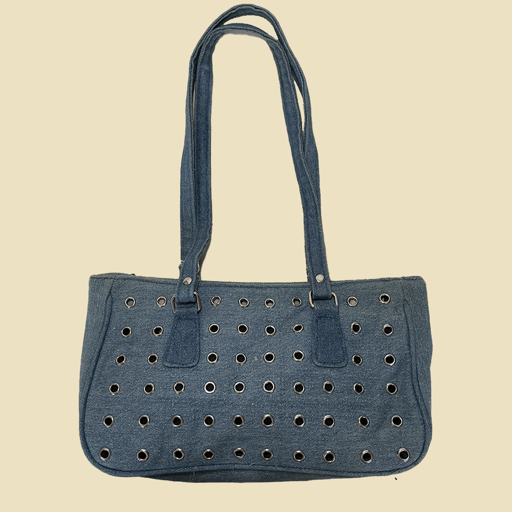 Sac baguette en denim à oeillets métalliques.