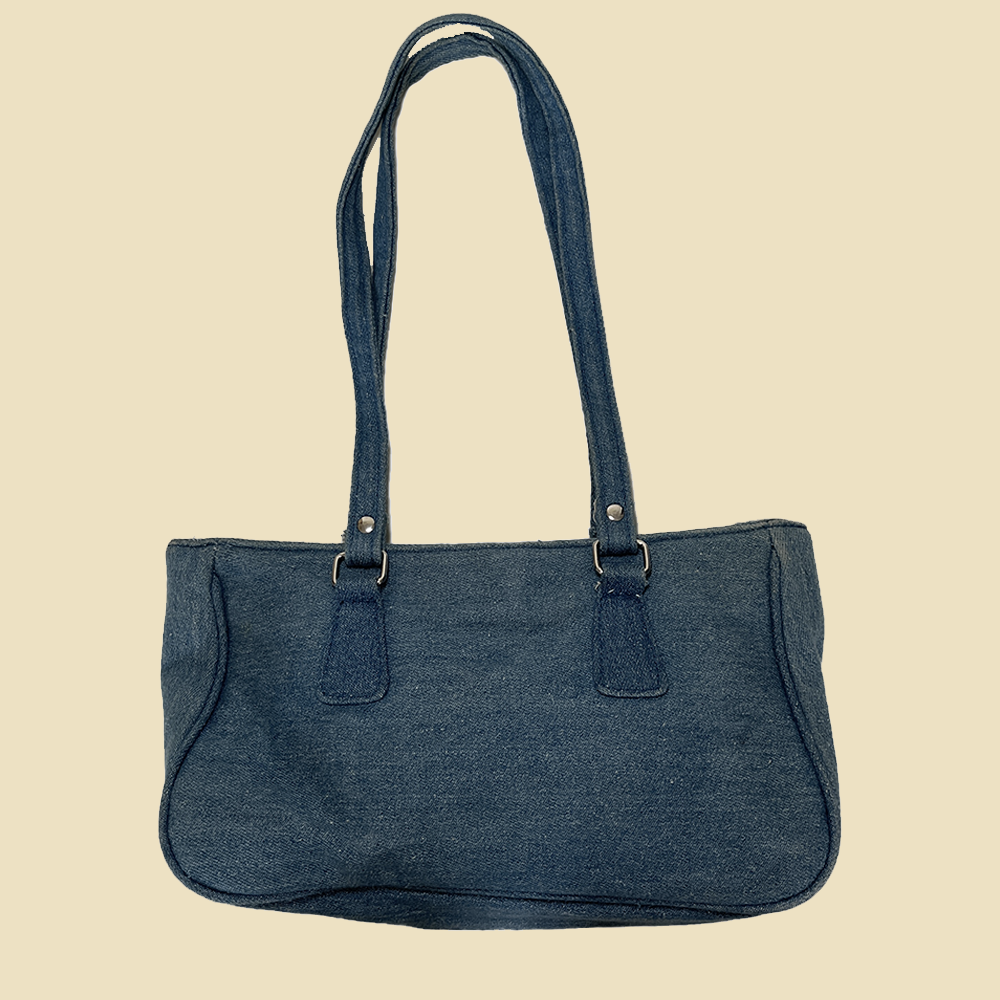 Sac baguette en denim à oeillets métalliques.